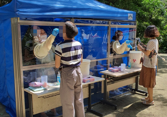 13일 부산 해운대구 부산기계공고 학생 3명이 확진 판정을 받자 교직원들이 진단검사를 받고 있다.  [해운대구청 제공]